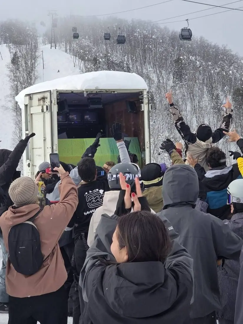 Hands up in front of the container booth on a snowy day