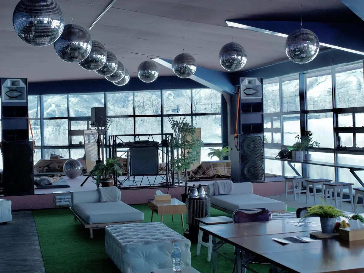 The heated indoor room — disco balls, daybeds and a wall of windows onto the mountain